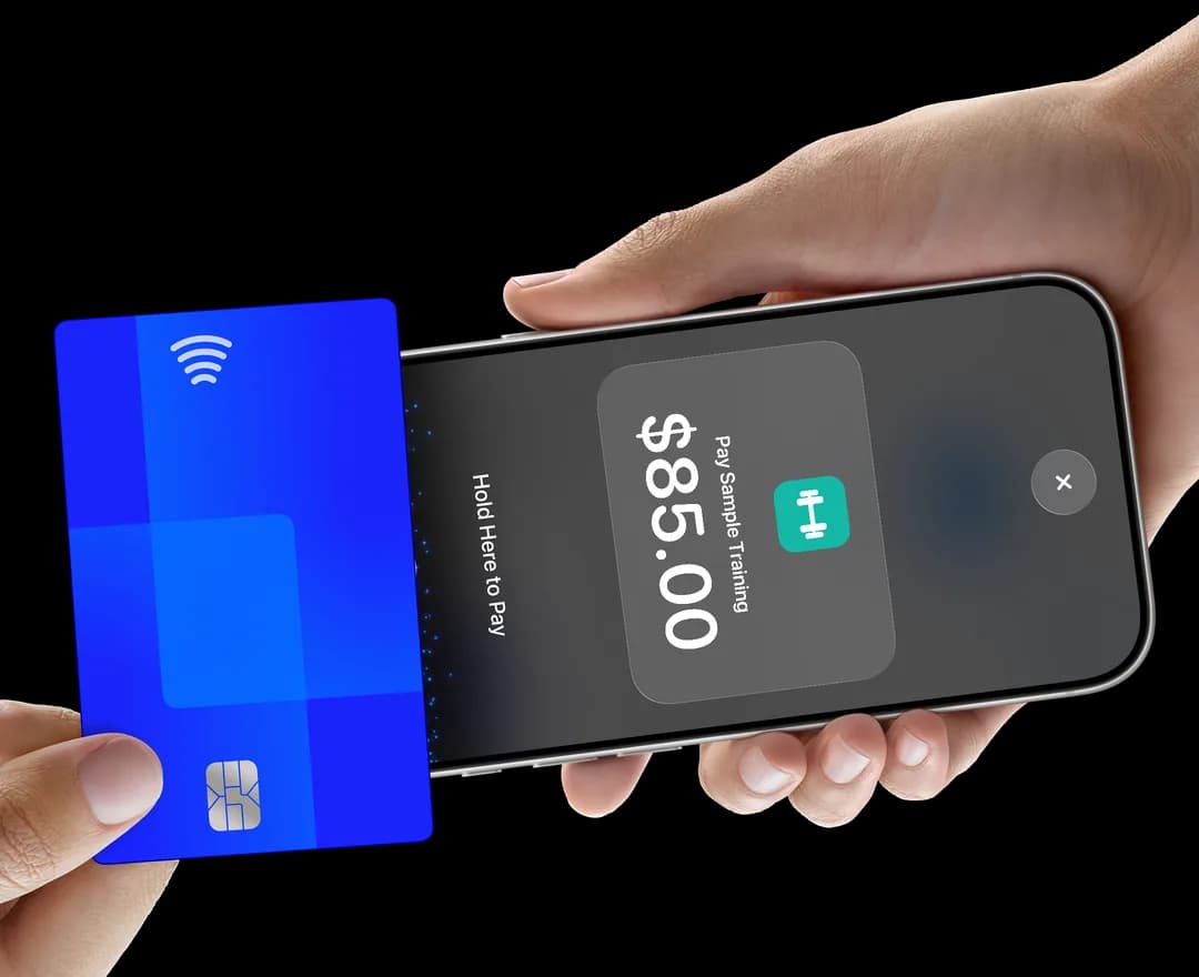 A customer holds a card over an iPhone showing Pay Sample Training.
